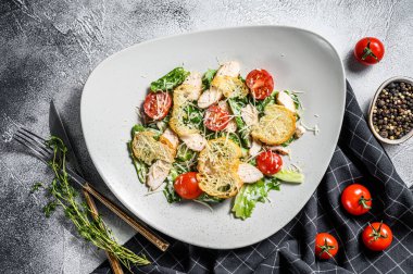 Kızarmış tavuklu Sezar salatası, kızarmış ekmek, bıldırcın yumurtası ve vişneli domates. Beyaz arka plan. Üst görünüm.