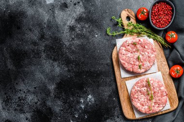 Çiğ tavuk köftesi, kıyma tahtasında kıymalı pirzola. Organik kıyma. Siyah arka plan. Üst Manzara. Boşluğu kopyala