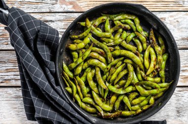Tavada yeşil edamame soya fasulyesi, Japon yemeği. Beyaz arka plan. Üst görünüm