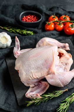 Biberiyeli ve pembe biberli çiğ tavuk. Siyah arka plan. Üst görünüm.