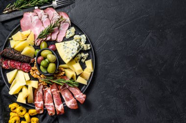 Prosciutto, jambon, peynir ve zeytinli tipik İtalyan antipasto. Siyah arka plan. Üst Manzara. Metin için boşluk.