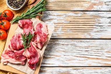 Mermer şeritler, kesme tahtasındaki hızlı biftek. Beyaz ahşap arka plan. Üst Manzara. Boşluğu kopyala.