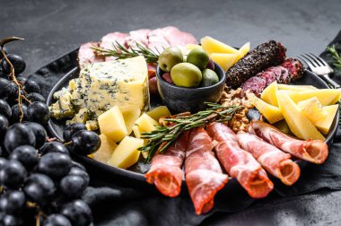 Prosciutto, jambon, peynir ve zeytinli tipik İtalyan antipasto. Siyah arka plan. Üst görünüm.