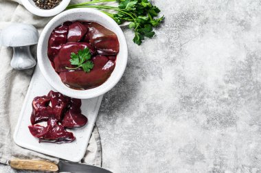 Tabakta çiğ hindi ciğeri. Gri arka plan. Üst Manzara. Metin için boşluk.