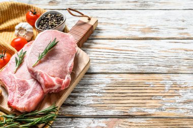 Çiğ domuz pirzolası. Organik et. Beyaz ahşap arka plan. Üst Manzara. Boşluğu kopyala.