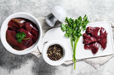 Tabakta çiğ ördek ciğeri. Gri arka plan. Üst görünüm.