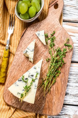 Üzümlü mavi peynir üçgeni. Beyaz ahşap arka plan. Üst Manzara. Boşluğu kopyala.