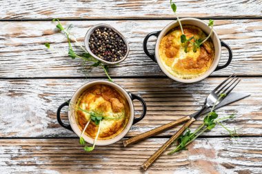 Tavada mikro yeşillik ve peynirli omlet. Beyaz ahşap arka plan. Üst görünüm.