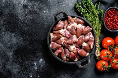 Tavada çiğ tavuk kalbi. Organik sakatat. Siyah arka plan. Üst Manzara. Boşluğu kopyala.
