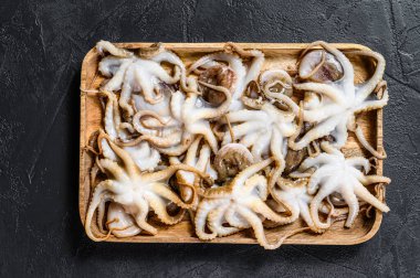 Siyah arka planda çiğ bebek ahtapot. Organik deniz ürünleri. Üst görünüm.