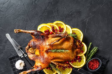 Portakal ve Rosmarina ile doldurulmuş fırında kaz. Kutlama masası. Siyah arka plan. Üst Manzara. Metin için boşluk.