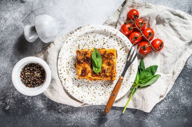 Geleneksel lazanya kıyma, bolonez ve beşamel sosuyla yapılır. Gri arka plan. Üst görünüm.