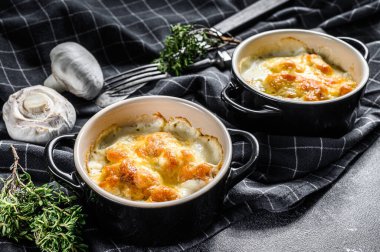 Julienne, tavuk ve mantarlı ve porsiyon şeklinde. Siyah arka plan. Üst görünüm.