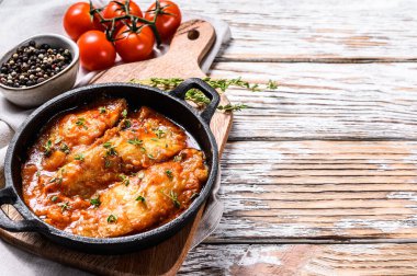 Tavada pişmiş halibut balığı ve domates sosu. Beyaz ahşap arka plan. Üst Manzara. Boşluğu kopyala