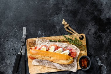 Jamon jambonlu sandviç, paleta iberica, kesim tahtasında Camembert peyniri. Siyah arkaplan, üst görünüm, metin için boşluk.