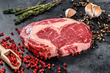 Çiğ et, baharatlı Ribeye Bifteği. Pirzola bifteği. Siyah arka plan. en üstteki görünüm.