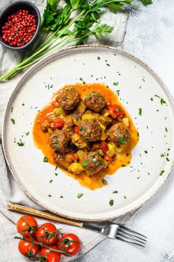 Domates soslu domuz köftesi ve tavada sebze. Gri arka plan. Üst görünüm.