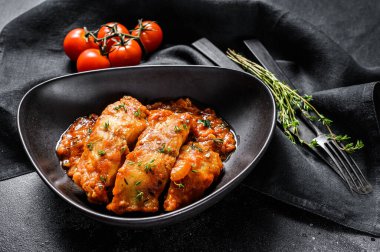 Fırında Tilapia balığı ve domates tabağı. Siyah arka plan. Üst görünüm.