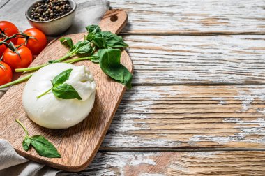 Basil yapraklı İtalyan Burrata bufalo peyniri. Beyaz ahşap arka plan. Üst Manzara. Boşluğu kopyala.