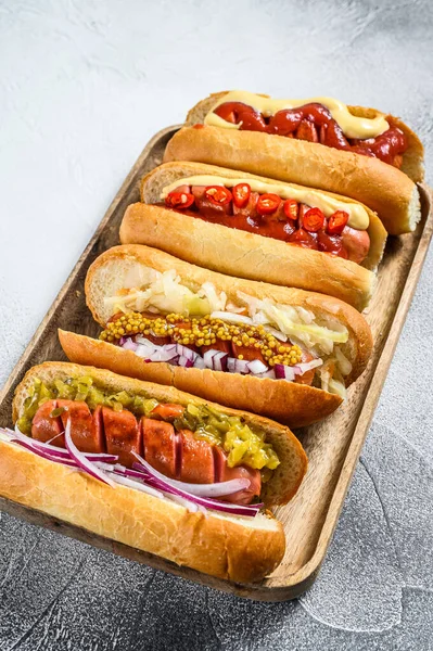 Tepside çeşitli malzemelerle dolu sosisliler. Domuz ve sığır etli sosisli nefis sosisler. Beyaz arka plan. Üst görünüm