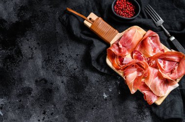 Prosciutto Crudo, İtalyan salamı, parma jambonu. Antipasto tabağı. Siyah arkaplan, üst görünüm
