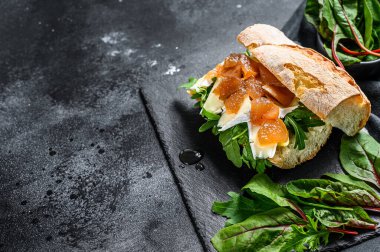 Keçi peynirli baget sandviç, armut reçeli, pazı ve ıspanak. Siyah arka plan. Üst Manzara. Boşluğu kopyala.