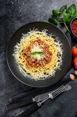 Domates soslu İtalyan spagettisi, peynirli parmesan ve fesleğen. Siyah arka plan. Üst görünüm.
