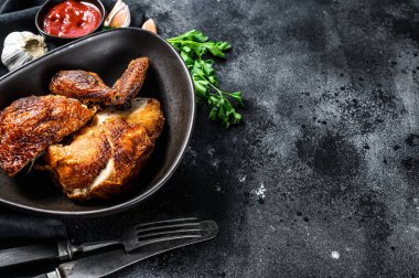 Tabakta yarım ızgara tavuk. Siyah arka plan. Üst Manzara. Boşluğu kopyala.