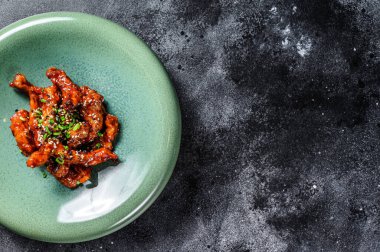 Asya yemeği: tatlı ve ekşi soslu baharatlı domuz eti. Siyah arka plan. Üst Manzara. Boşluğu kopyala.