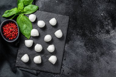 Mini mozarella peyniri topları, Caprese salatası için malzemeler. Siyah arka plan. Üst Manzara. Boşluğu kopyala.