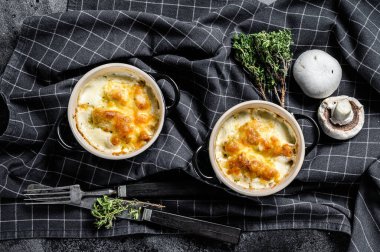 Julienne, tavuk ve mantarlı ve porsiyon şeklinde. Siyah arka plan. Üst görünüm.