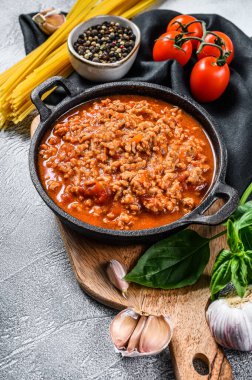 Domates, peynir ve fesleğenli makarna spagettisi pişirme fikri. Gri arka plan. Üst görünüm.