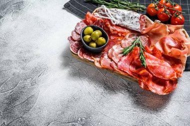 İspanyol soğuk et çeşitleri. Chorizo, fuet, LOMO, jamon Iberico, zeytin. Gri arka plan. Üst Manzara. Boşluğu kopyala.