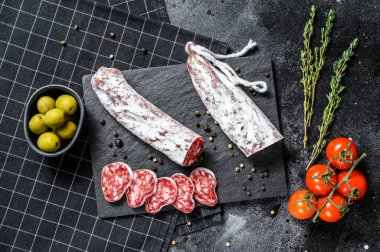 Fuet Salam dilimleri ve Rosemary. Geleneksel İspanyol sosisi. Siyah arka plan. Üst görünüm.