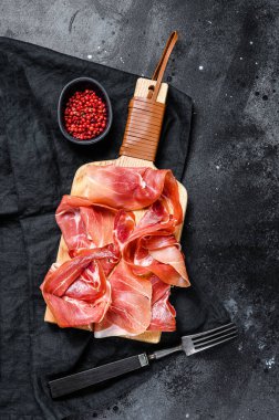 İspanyol jamonu Serrano, jambon. Siyah arkaplan, üst görünüm.