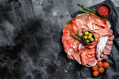 İspanyol soğuk et çeşitleri. Chorizo, fuet, LOMO, jamon Iberico, zeytin. Siyah arka plan. Üst Manzara. Boşluğu kopyala.