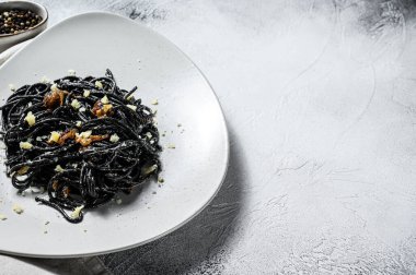 Biber soslu ve parmesanlı siyah spagetti makarna. Gri arka plan. Üst Manzara. Boşluğu kopyala.