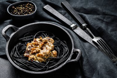 Krema soslu somonlu siyah spagetti makarna. Siyah arka plan. Üst görünüm.