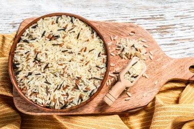 Jasmine, Brown, Red and Black Rice bir kase içinde. Karışık pirinç ve Riceberry. Beyaz arka plan. Üst görünüm.