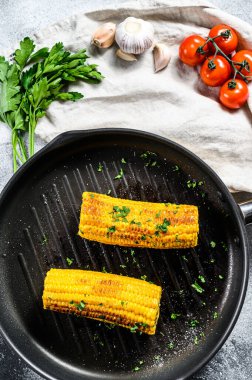 Kızartma tavasında organik ızgara mısır. Organik çiftlik sebzeleri. Gri arka plan. Üst görünüm.