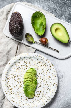Dilimlenmiş avokado. Gri arka plan. Üst görünüm.