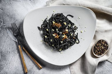 Biber soslu ve parmesanlı siyah spagetti makarna. Gri arka plan. Üst görünüm.