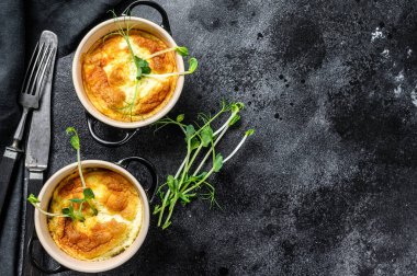 Peynirli omlet, tavada mikroyeşillik olan omlet. Siyah arka plan. Üst Manzara. Boşluğu kopyala.