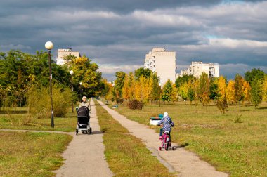 Zhovti Vody, Dnipro / Ukrayna - 02 / 10 / 2019: Pembe bisikletli bir kız cadde boyunca yürüyor.