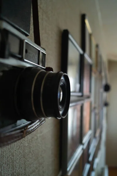 Camera and frames on the wall. Camera lens on the wall.