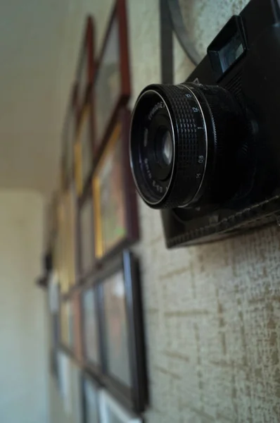 Camera and frames on the wall. Camera lens on the wall.