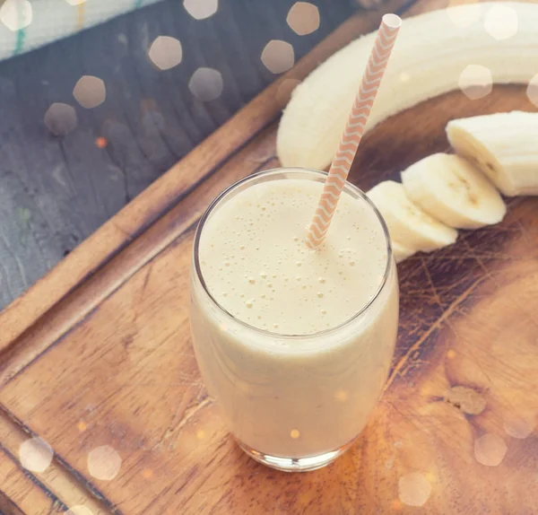 Banana smoothie on a rustic wooden table — Stock Photo, Image