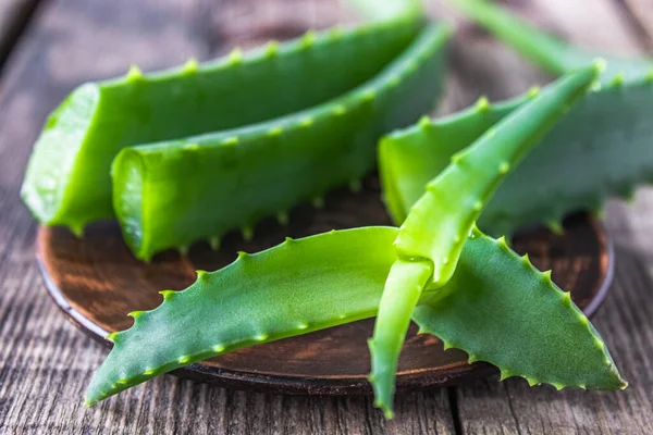 Foglie verdi di aloe primo piano su uno sfondo di legno . — Foto Stock