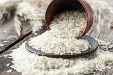 Bir kase beyaz pirinç, eski tahtaların arkasına serpilmiş pirinç serpiştirilmiş. Yasemin pilavı..