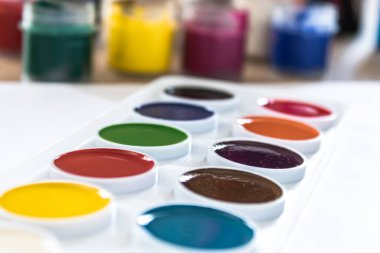 Suluboya boyaları beyaz arka planda yatar. Çizim, yaratıcılık ve hobiler için hazır. Yakın plan..